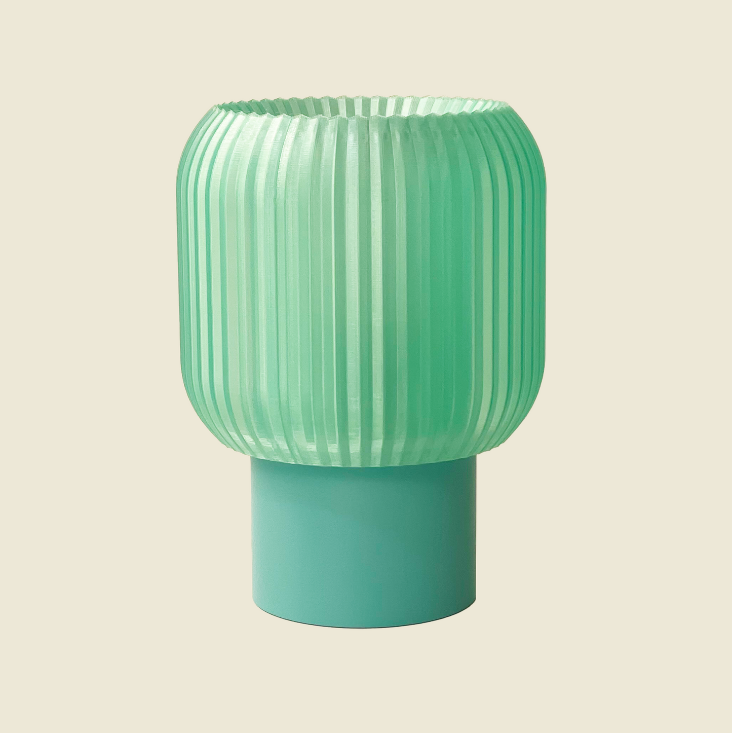 a green vase sitting on top of a table