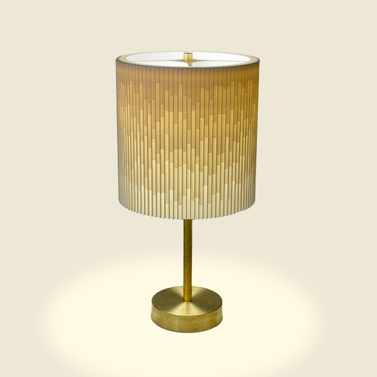 a gold lamp with a white shade on it