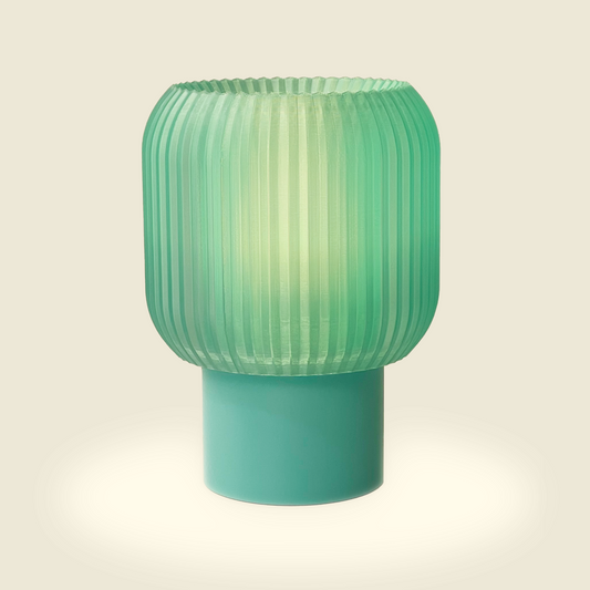 a green lamp sitting on top of a table