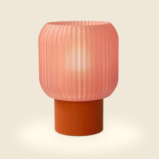 a pink lamp sitting on top of a wooden table